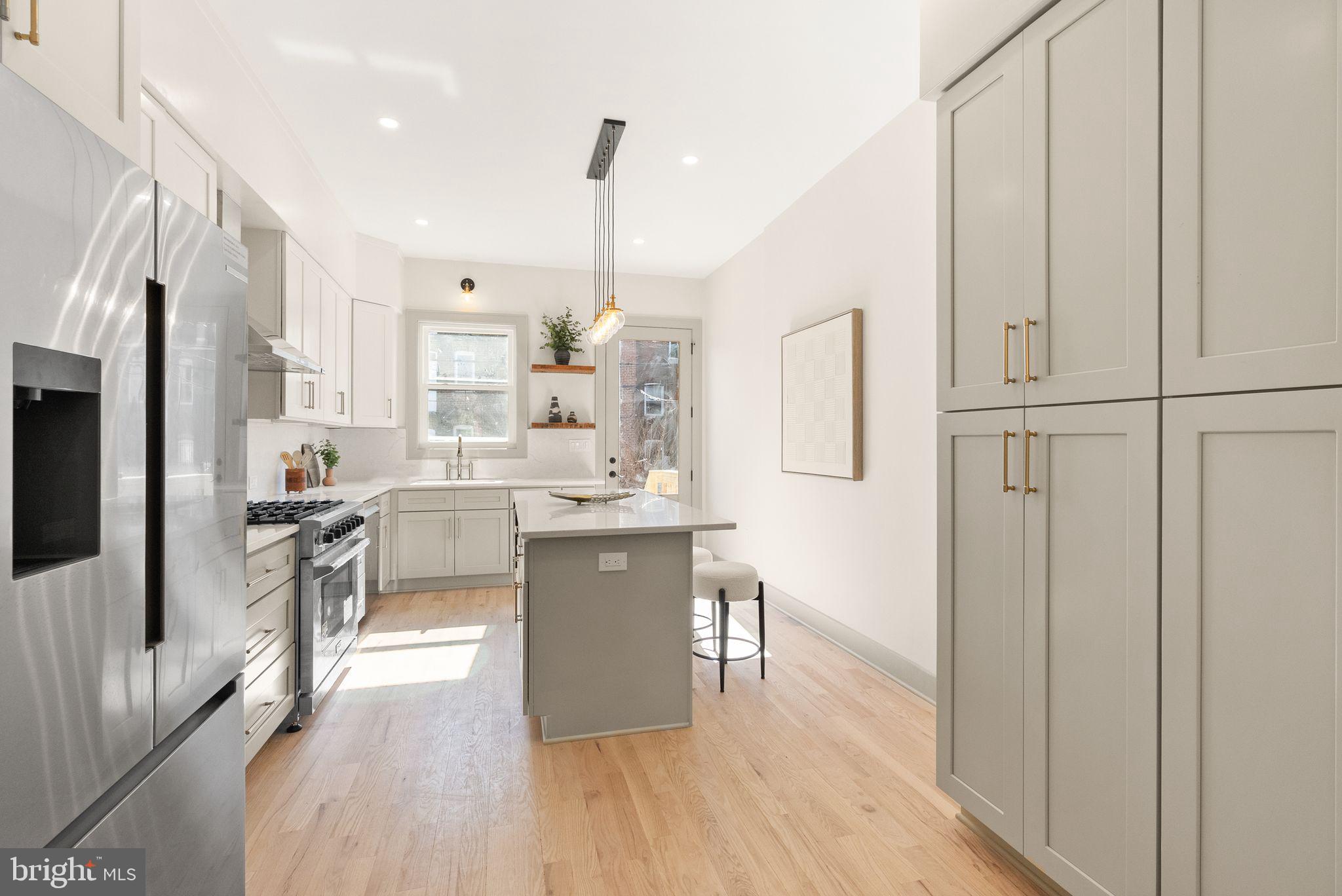 52 S Street Northwest Washington, DC 20001 - Photo 7 of 30 a kitchen with stainless steel appliances a refrigerator a sink dishwasher a oven with white cabinets and wooden floor