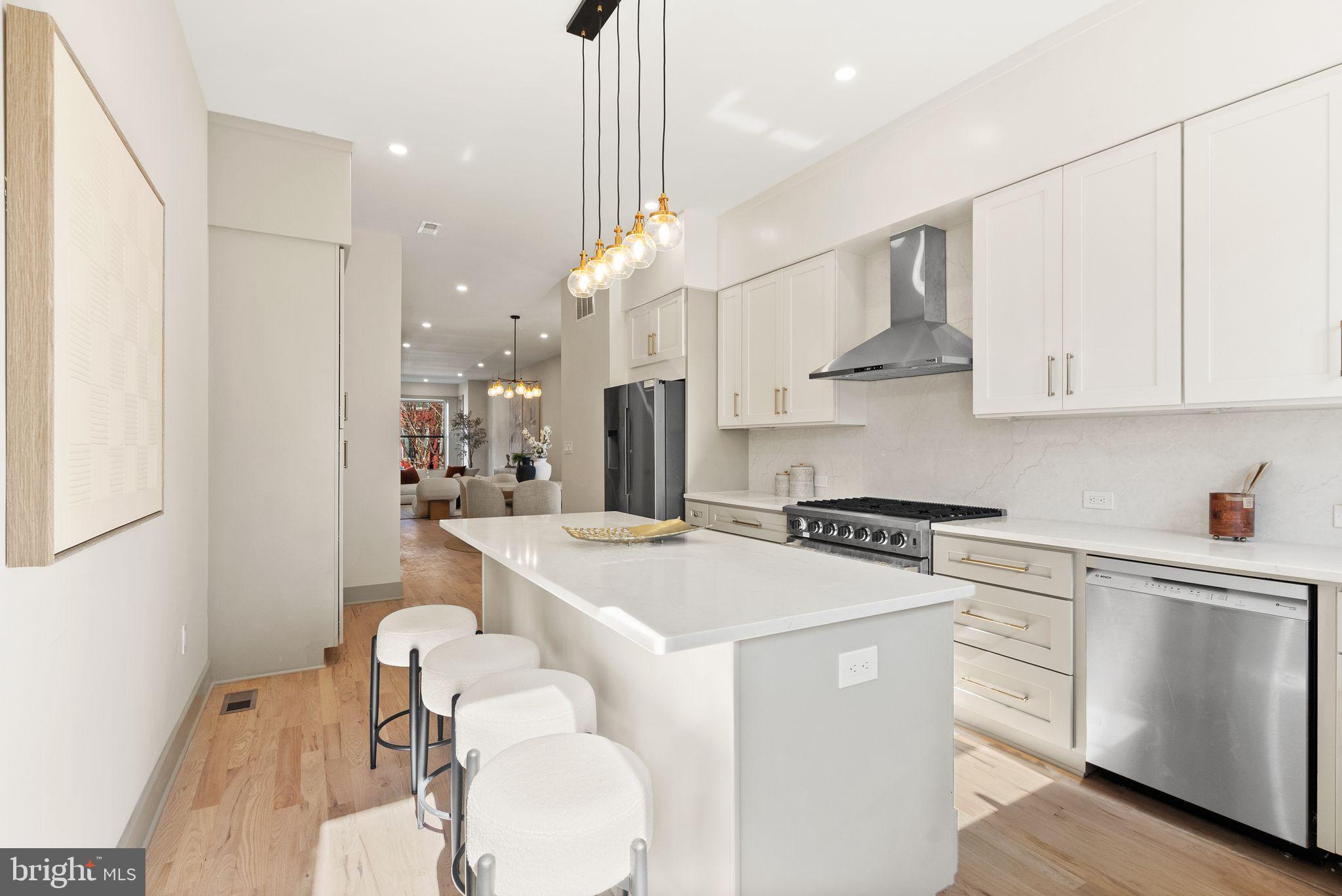 52 S Street Northwest Washington, DC 20001 - Photo 10 of 30 a kitchen with stainless steel appliances kitchen island granite countertop a sink a stove a refrigerator and white cabinets