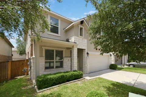 a front view of a house with a yard and trees