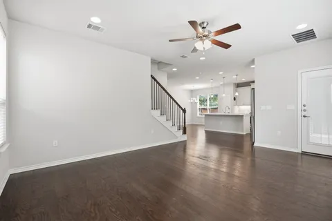 a kitchen with stainless steel appliances granite countertop a sink a stove a refrigerator and a oven with wooden floor