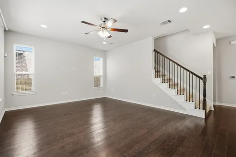 a kitchen with stainless steel appliances granite countertop a refrigerator a sink dishwasher a stove and white cabinets with wooden floor