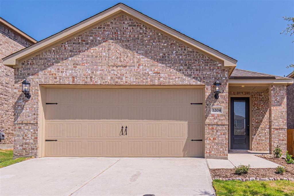 Ranch-style house featuring brick siding, a garage, and concrete driveway