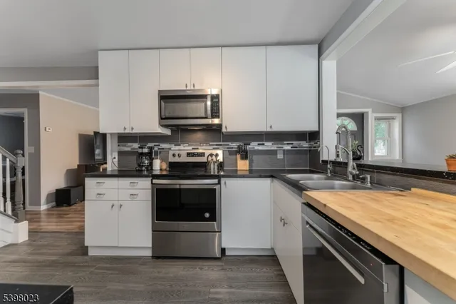 a kitchen with stainless steel appliances a stove microwave and sink