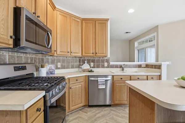 a kitchen with a sink stove top oven and cabinets