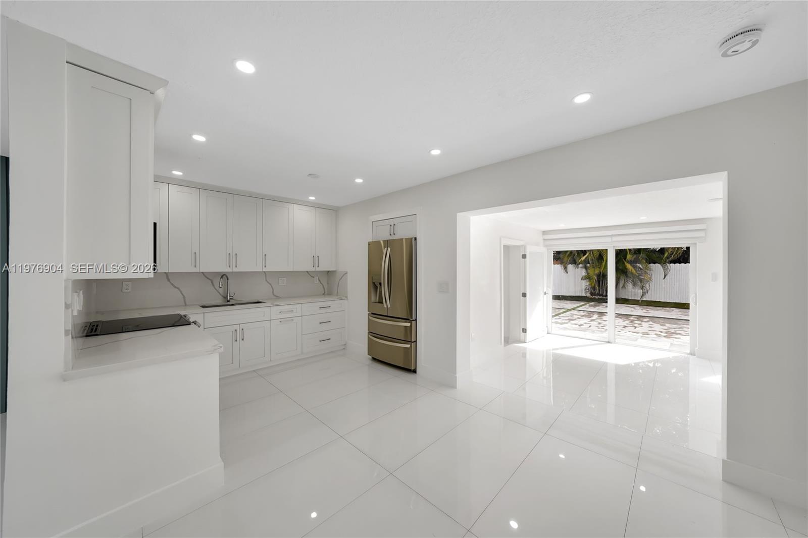 5635 West 13th Court Hialeah, FL 33012 - Photo 11 of 47 a kitchen with a refrigerator and white cabinets