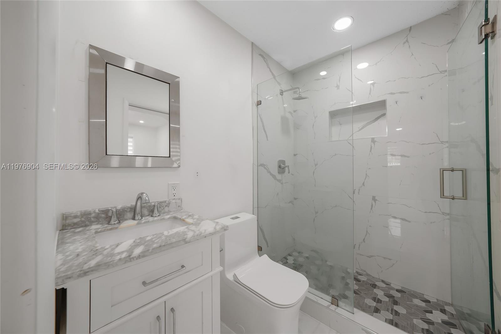 5635 West 13th Court Hialeah, FL 33012 - Photo 26 of 47 a bathroom with a granite countertop sink a toilet and shower