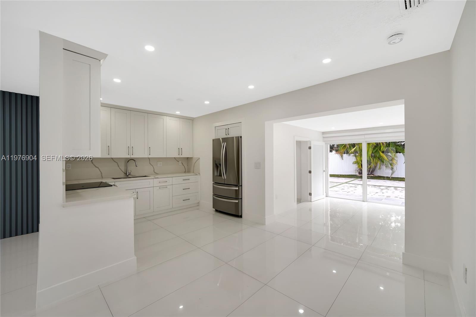 5635 West 13th Court Hialeah, FL 33012 - Photo 28 of 47 a kitchen with a refrigerator and white cabinets