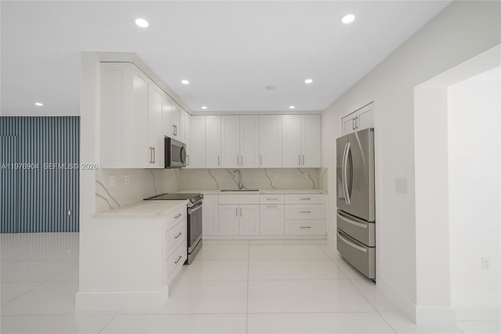 5635 West 13th Court Hialeah, FL 33012 - Photo 8 of 47 a kitchen with a refrigerator sink and cabinets