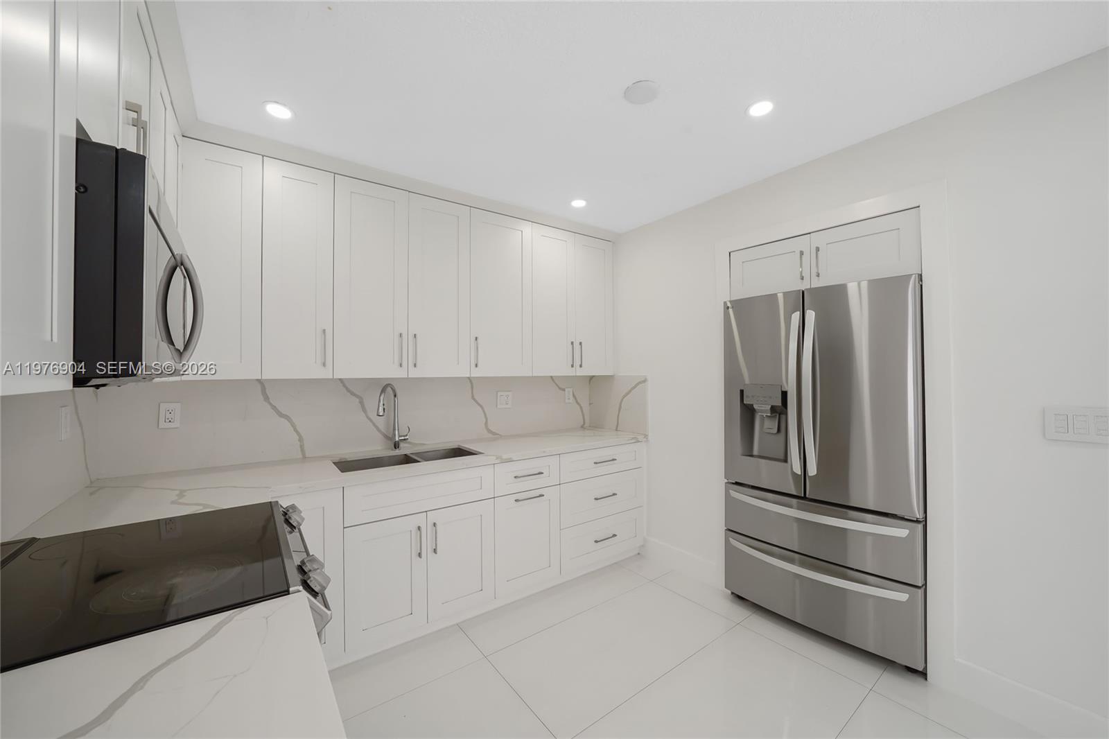 5635 West 13th Court Hialeah, FL 33012 - Photo 10 of 47 a kitchen with stainless steel appliances granite countertop a refrigerator and a stove