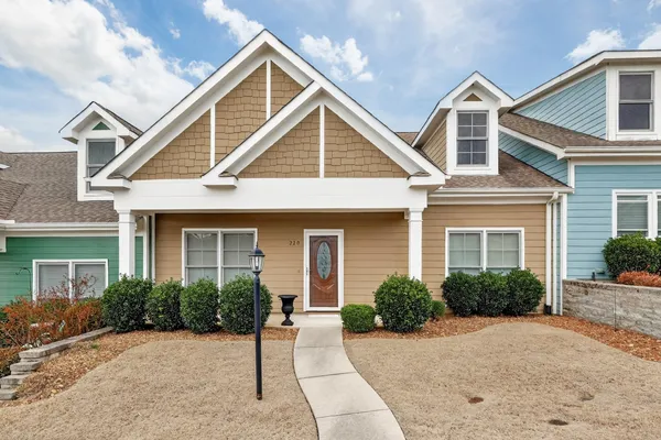 a view of a house with small yard plants and palm tree