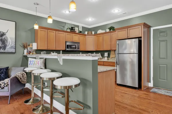 a kitchen with kitchen island a dining table chairs refrigerator and sink