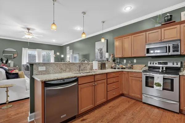 a kitchen with stainless steel appliances granite countertop a stove a sink and a microwave