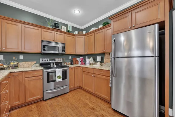 a kitchen with stainless steel appliances granite countertop a refrigerator a stove a sink and a microwave