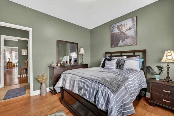 a bedroom with bed and wooden floor