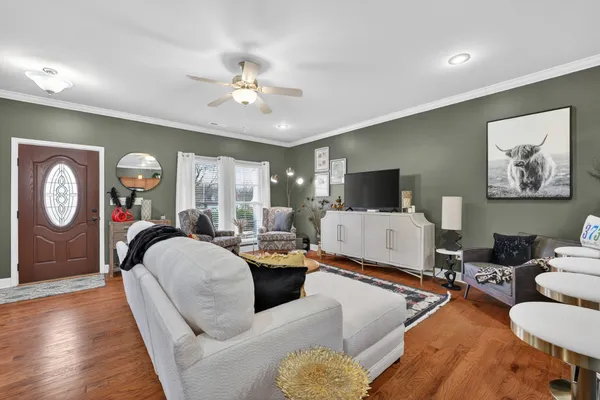 a living room with furniture a large window and a flat screen tv
