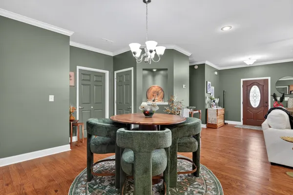 a view of a dining room with furniture a chandelier and wooden floor