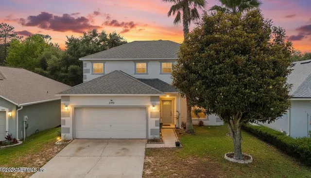 a front view of a house with a yard and garage