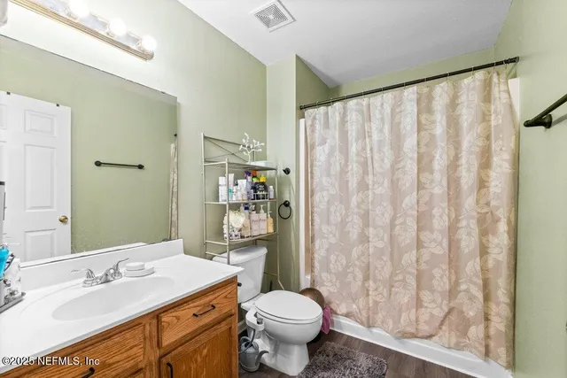 a spacious bathroom with a granite countertop sink toilet and shower