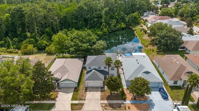 an aerial view of a house with a yard and tree s