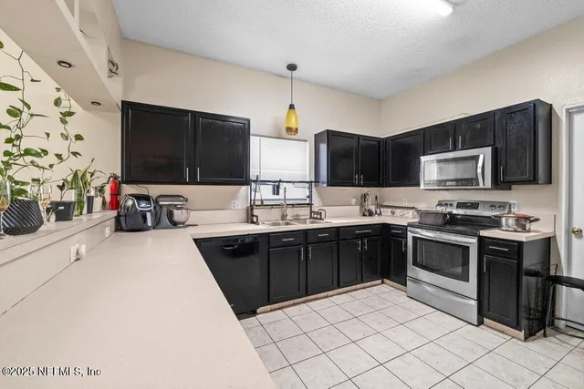 a kitchen with stainless steel appliances a stove sink microwave and cabinets
