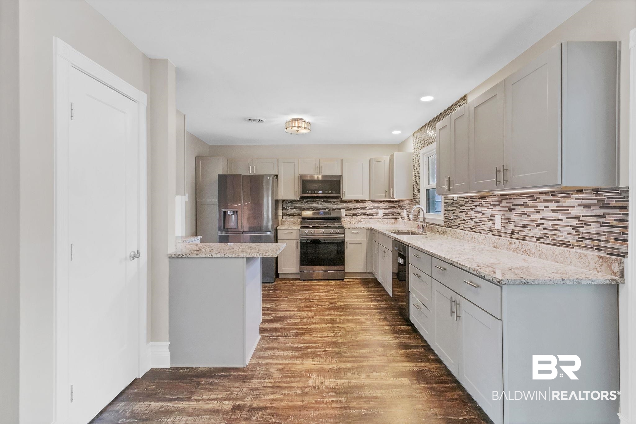 2901 Alston Court Mobile, AL 36605 - Photo 12 of 59 Kitchen with a sink, backsplash, granite countertops, wood finished floors, and stainless-steel appliances