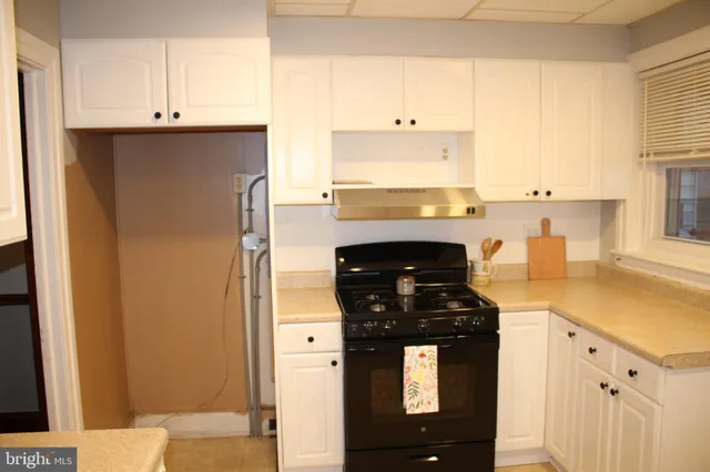 a kitchen with white cabinets and white appliances