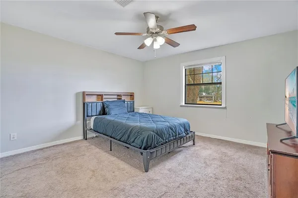 a spacious bedroom with a bed and a window