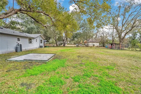 a view of a house with a big yard and large trees