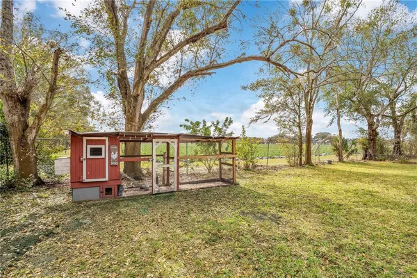 a view of a house with backyard and tree