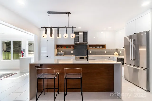a kitchen with stainless steel appliances granite countertop a sink and a refrigerator
