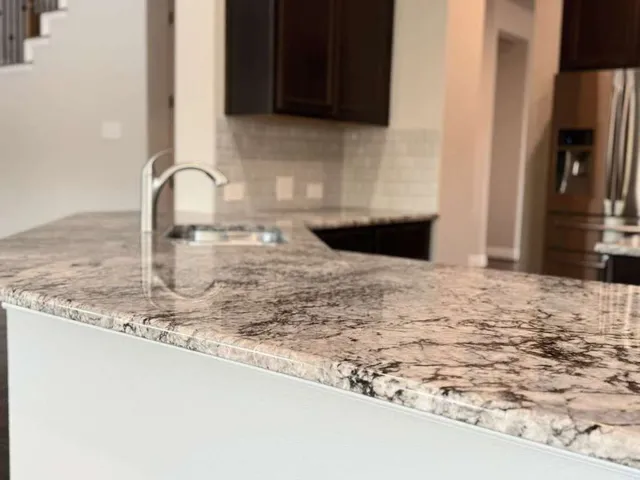 a kitchen with granite countertop a sink and a stove top oven