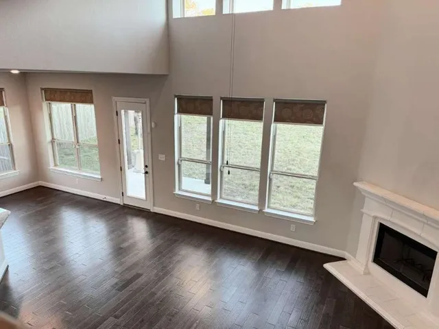 an empty room with wooden floor and fireplace