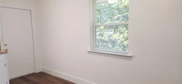 a view of a small space with wooden floor and a window