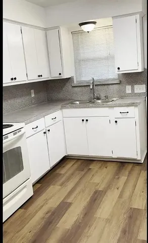 a kitchen with granite countertop white cabinets and a sink