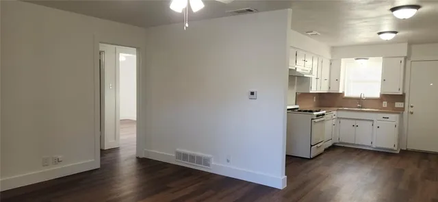 a view of a kitchen with refrigerator and window
