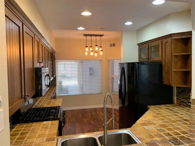 a view of a room with wooden floor and a ceiling fan