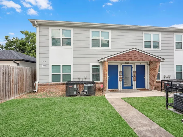 a front view of a house with a garden and yard