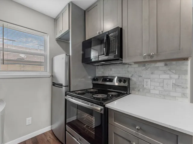 a kitchen with stainless steel appliances a stove microwave and sink