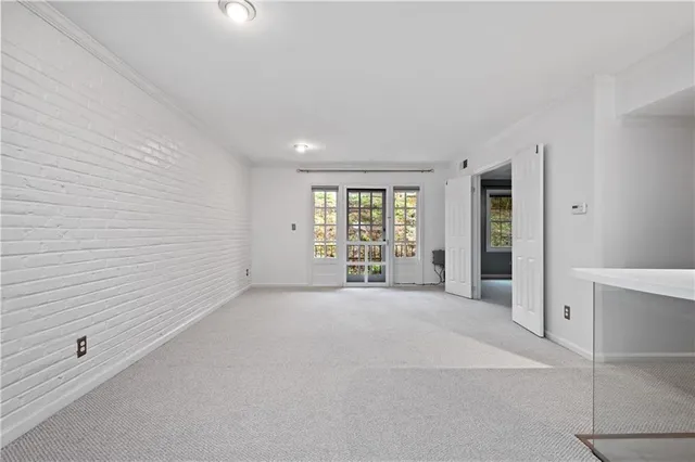 a view of a livingroom with wooden floor kitchen and windows
