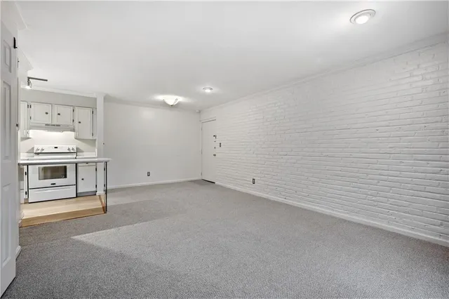 a kitchen with kitchen island a sink white cabinets and stainless steel appliances