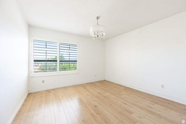 161 West 950 South, Unit C5 St. George, UT 84770 - Photo 12 of 14 Room with wood-finish flooring, white walls, and a multi-pane window with horizontal blinds