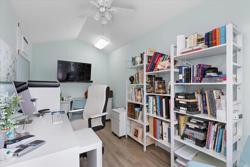 3069 West Canyon Avenue San Diego, CA 92123 - Photo 22 of 37 a living room with lots of books furniture and a flat screen tv