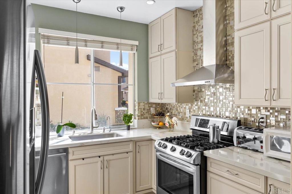 3069 West Canyon Avenue San Diego, CA 92123 - Photo 9 of 37 a kitchen with stainless steel appliances a stove a sink and a window