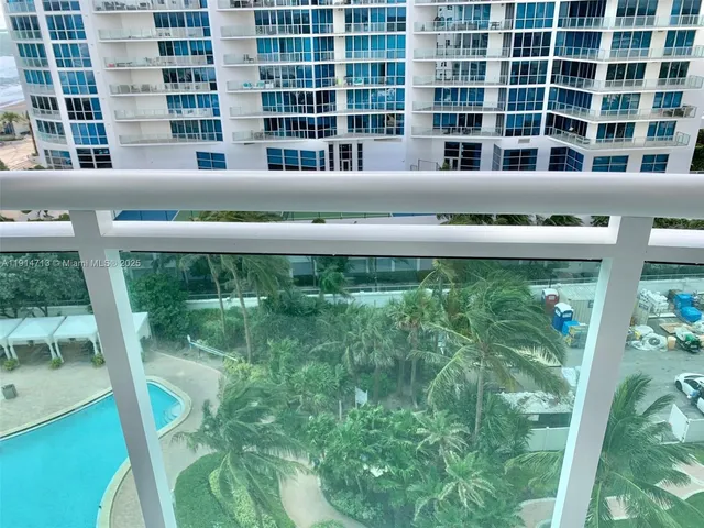 a front view of a building with a yard and fountain