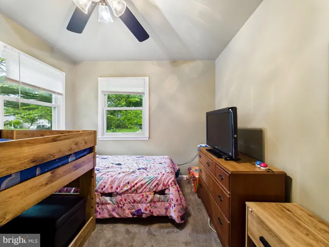 a bedroom with a bed and a flat tv screen on the dresser