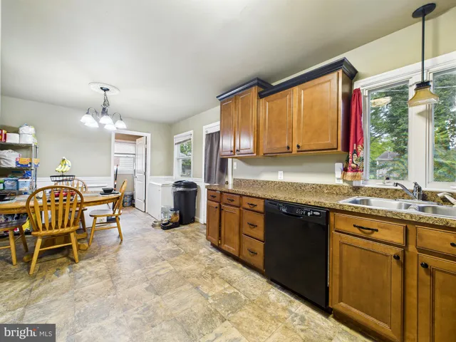 a kitchen with kitchen island granite countertop a sink stove and cabinets