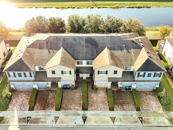 an aerial view of houses with outdoor space and water