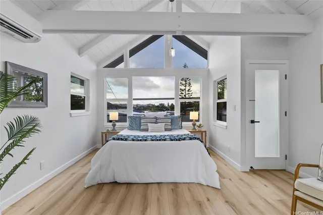 a spacious bedroom with a bed and a wooden floor