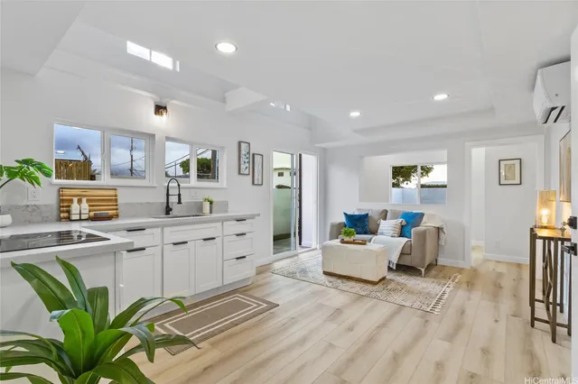 a living room with furniture a wooden floor and a sink