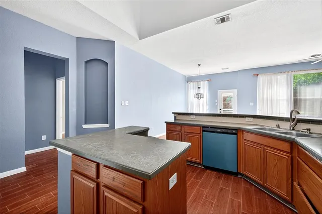 a kitchen with stainless steel appliances granite countertop wooden cabinets a sink and a large window